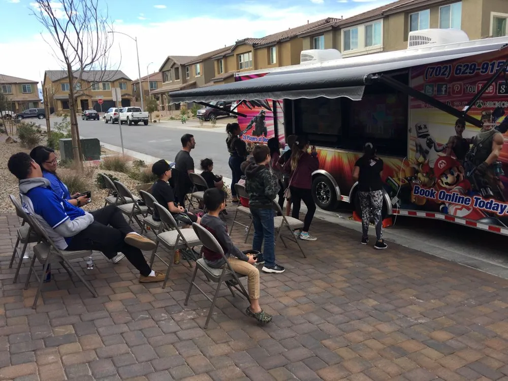 Families in folding chairs watching the outdoor screens at a neighborhood event