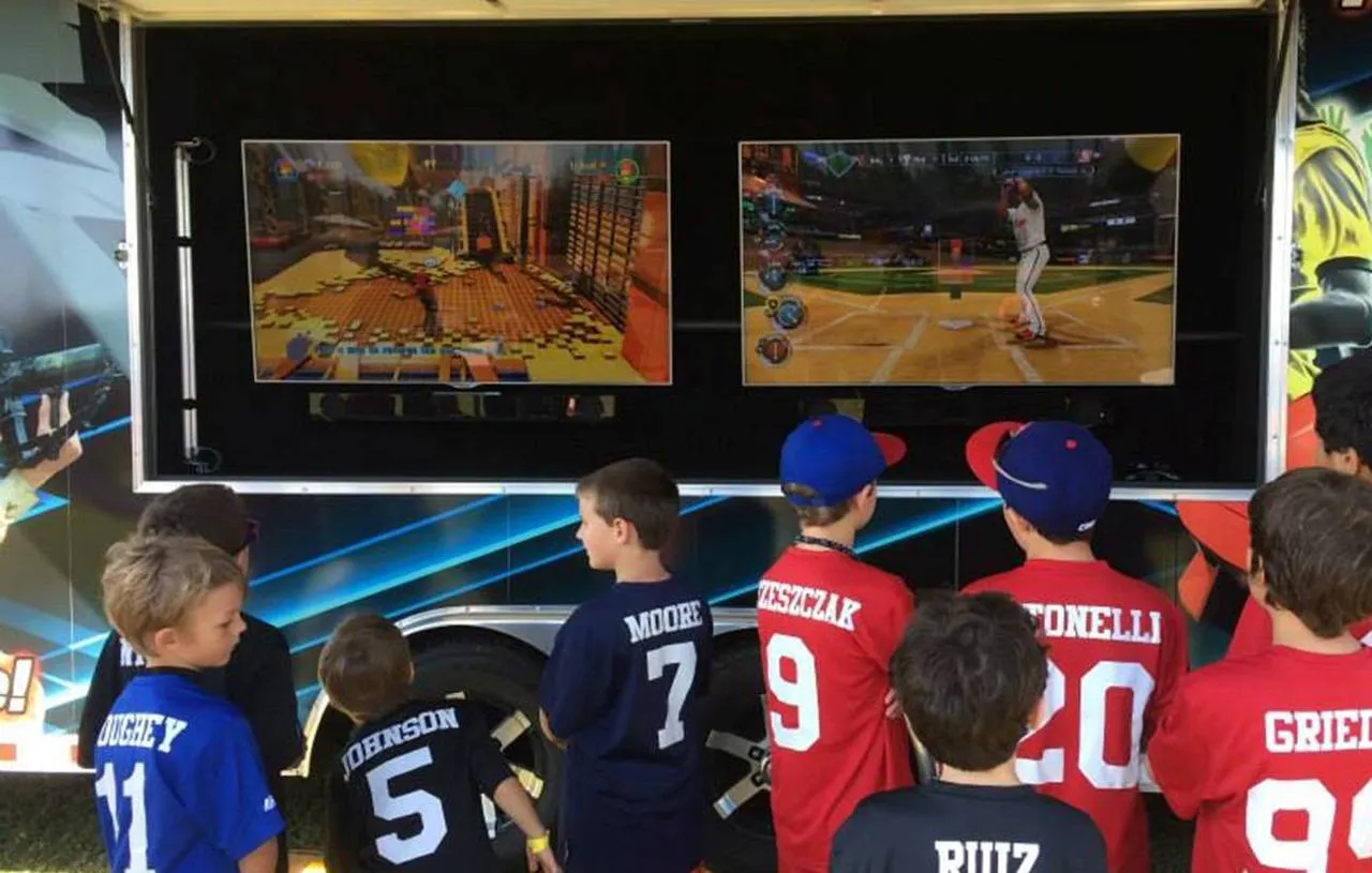 A youth baseball team in jerseys playing at the trailer’s two outdoor screens