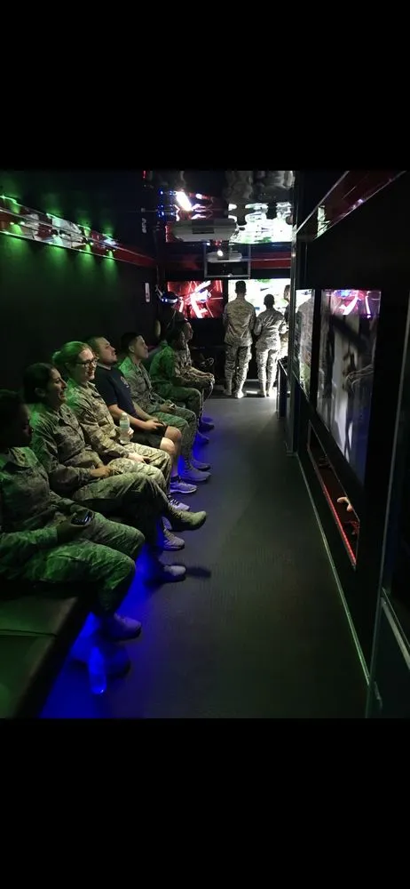 Service members in uniform gaming inside the Vegas Gamerz trailer at a corporate event