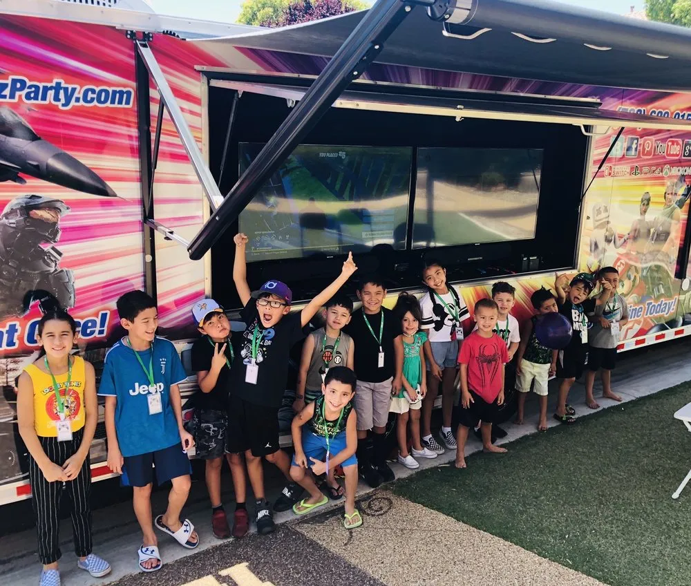 A group of kids posing in front of the outdoor gaming screens