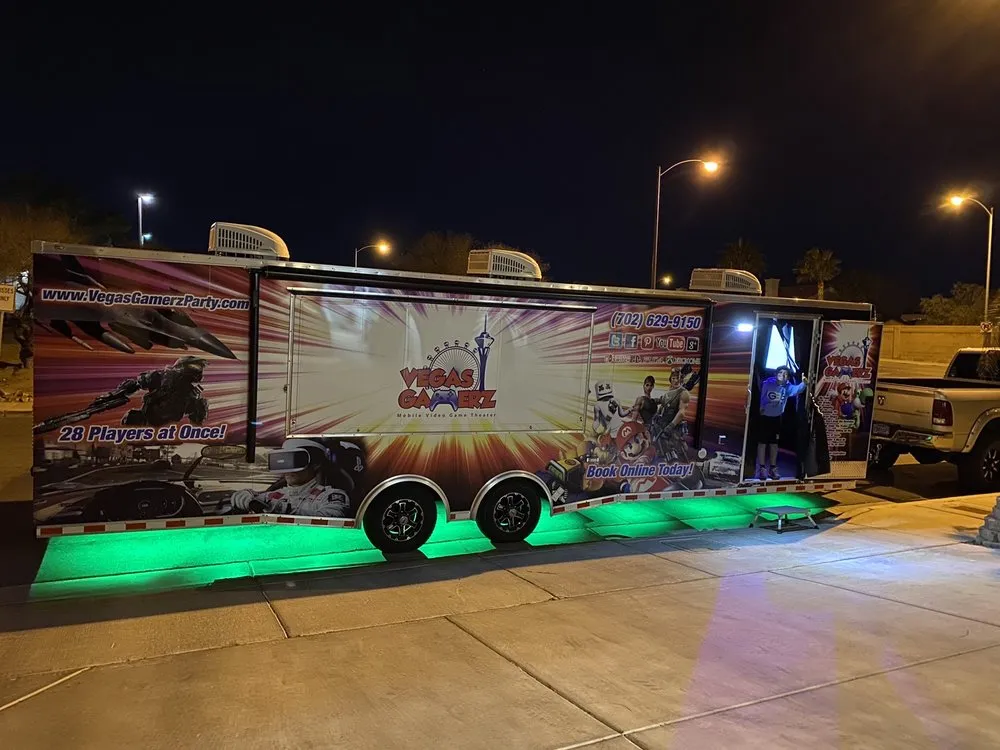 The trailer lit green at night with the awning out